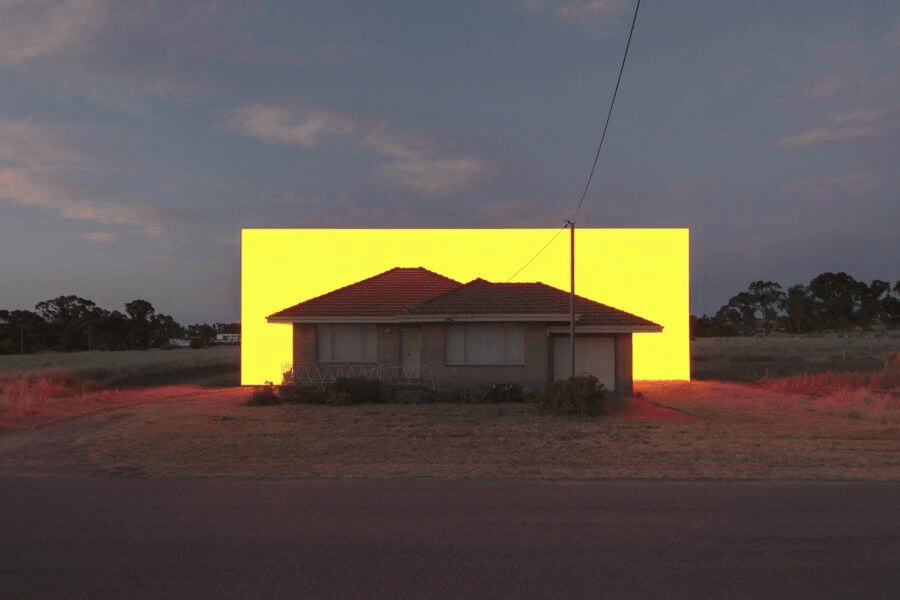 A rural house framed by an illuminated installation