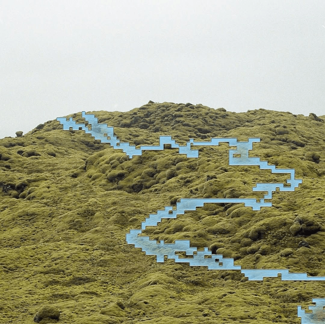 A mirrored installation crossing a green landscape